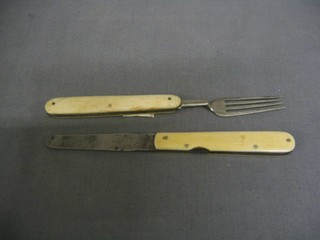 A 19th Century folding knife and fork set with steel blades and ivory grips the fork incorporating a corkscrew