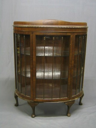 A 1930's Chippendale style walnutwood bow front display cabinet fitted adjustable shelves enclosed by a glazed panelled door, raised on cabriole supports 41"