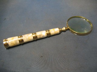 A silver plated magnifying glass with faceted glass handle