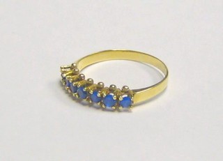 A gold half eternity ring set blue stones