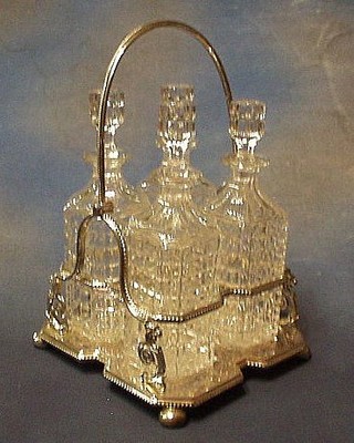 A Victorian silver plated 4 bottle decanter stand with swing handle, raised on 4 bun feet, fitted 4 cut glass decanters