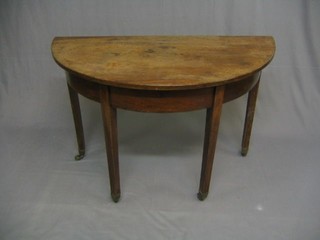 A 19th Century mahogany demi-lune table raised on pillar and tripod supports ending in brass caps and castors 42"