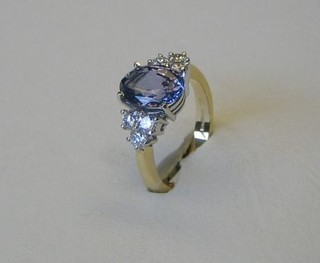 A lady's modern 18ct gold dress ring set a handsome oval cut Ceylonese sapphire supported by 6 diamonds (sapphire approx 2.40 ct, diamonds approx .52 ct)