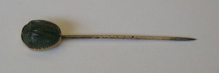 A gilt metal stick pin decorated a scarab