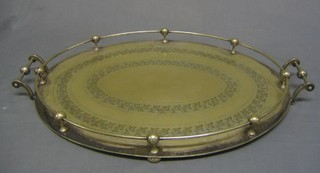 A large and impressive engraved oval silver plated twin handled tea tray raised on bun feet (1 missing) 25"