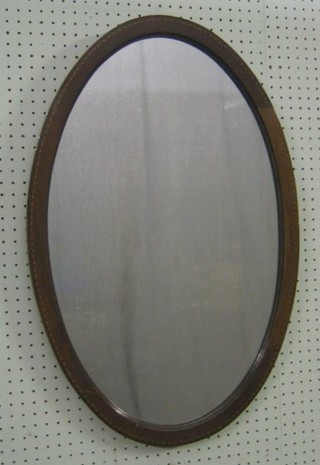 An Edwardian oval plate mirror contained in an inlaid mahogany frame 29"