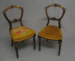 A pair of Victorian mahogany balloon back dining chairs with shaped mid rails and upholstered seat, raised on turned and fluted supports