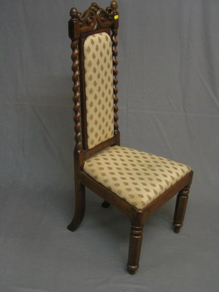 A Victorian oak nursing chair with upholstered seat and back and spiral turned columns to the side, raised on chamfered supports
