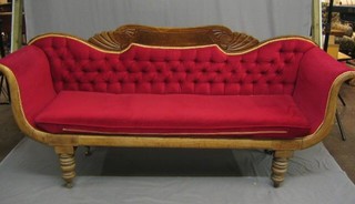 A William IV show frame mahogany sofa with carved bar back, upholstered in red material, raised on turned supports 82"