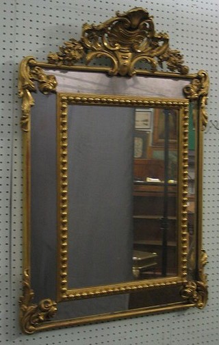A 19th Century French rectangular plate wall mirror contained in a decorative ball studded frame surmounted by a Rococo crest 34"