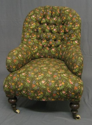 A Victorian mahogany framed tub back chair upholstered in buttoned floral material, on turned mahogany supports ending in brass caps and castors