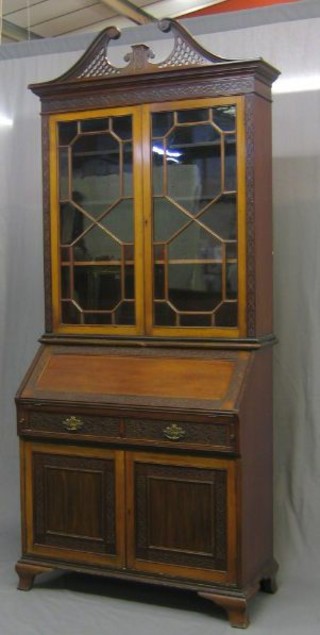 An  Edwardian mahogany Chippendale style bureau bookcase, the upper section with pierced broken pediment and blind fret work frieze, the interior fitted adjustable shelves enclosed by astragal glazed doors, the fall front revealing a well fitted interior above 2 short drawers, the base fitted a double cupboard enclosed by panelled doors, raised on bracket feet 38"