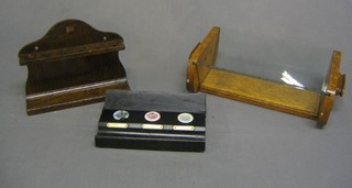 An oak arch shaped pipe rack 9", an Art Deco honey oak twin handled book trough 13" and an ebonised 3 bottle inkwell with pen recess 9"