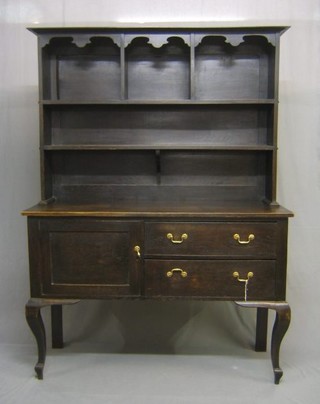 An Art Nouveau oak dresser with raised back and moulded cornice, the upper section fitted 2 shelves, the base fitted 2 drawers flanked by a cupboard, raised on cabriole supports 54"