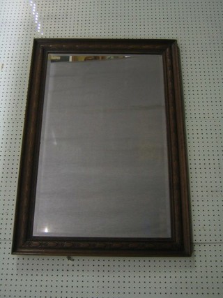 A Victorian rectangular bevelled plate wall mirror contained in a carved oak frame 39"