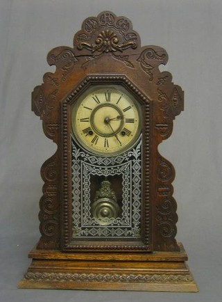 A 19th Century American 8 day striking shelf clock with paper dial, Roman Numerals contained in a carved oak base by Ansonia Clock Co.