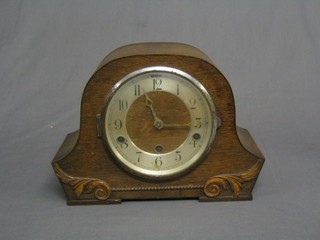 A 1930's 8 day striking mantel clock with Arabic numerals contained in an oak arched case
