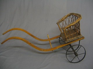A 19th/20th Century wooden dog cart with wicker seat and iron wheels