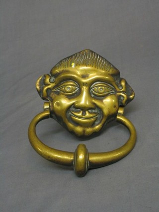 A 19th Century brass door knocker in the form of a head