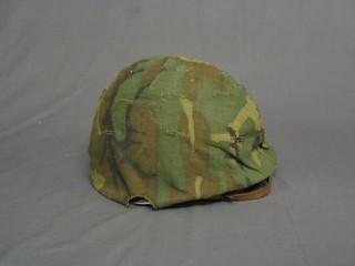 An American steel helmet complete with liner, chin strap and camouflage cover