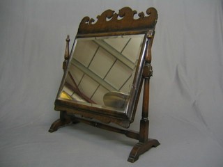 A rectangular bevelled plate Queen Anne style dressing table mirror contained in a shaped walnutwood swing frame 22"