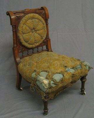 An Edwardian carved walnut nursing chair with rail back and upholstered seat and back with bobbin turned decoration, raised on turned and fluted supports