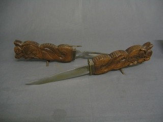 An Indian steel carving set contained in a carved case decorated stylised dragons