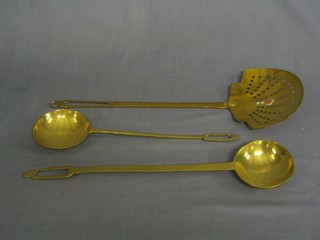 A pierced brass cream skimmer and 2 brass "range" spoons