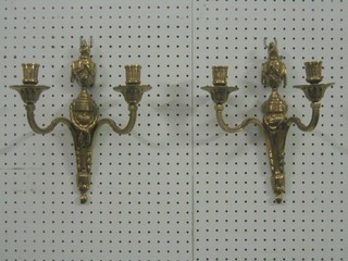 A pair of gilt metal twin light wall brackets surmounted by a lidded urn  12"