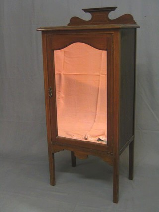 An Edwardian inlaid mahogany music cabinet with raised back, the interior fitted adjustable shelves enclosed by an arch shaped bevelled plate, panelled mirror door, raised on square tapering supports 21"