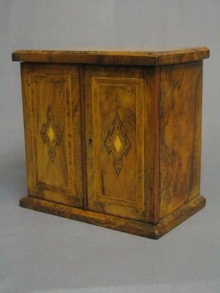 A Victorian figured walnutwood table top cabinet, the interior fitted 3 drawers enclosed by inlaid panelled doors, 12"