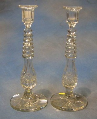 A pair of 19th/20th Century cut glass candlesticks raised on circular bases 13"