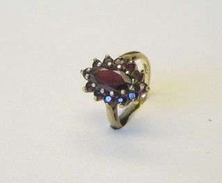 A lady's 9ct gold dress ring set an oval cut garnet supported by garnets