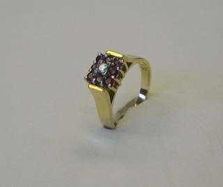A lady's 18ct gold dress ring set a diamond surrounded by 12 rubies