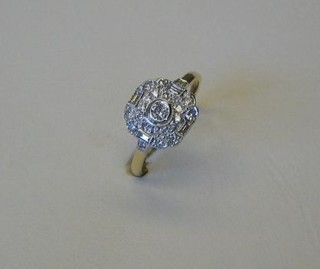 A lady's gold dress ring set a circular diamond supported by 4 baguette cut diamonds and numerous other stones (approx 0.55ct)