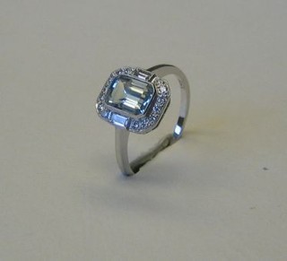 A lady's 18ct white gold dress ring set a rectangular cut aquamarine supported by 2 baguette cut diamonds and numerous other diamonds 
