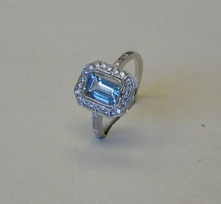 A lady's 18ct white gold dress ring set a rectangular cut aquamarine supported by numerous diamonds and with 6 diamonds to the shoulders