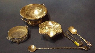 A circular silver plated twin handled dish 6", a pierced silver plated butter dish, a shaped silver plated bowl, silver plated sugar tongs, a caddy spoon and a cocktail spoon