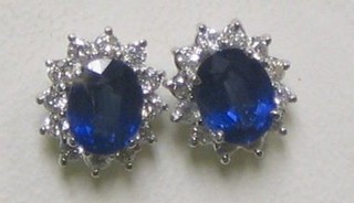 A pair of 18ct white gold ear studs set oval cut sapphires surrounded by diamonds