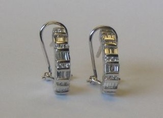 A pair of modern 18ct white gold earrings set numerous baguette cut diamonds