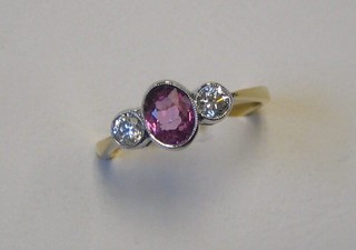 A lady's 18ct gold dress ring set an oval cut pink sapphire supported by 2 circular cut diamonds