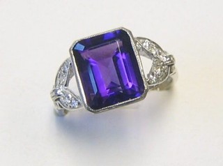 A lady's 18ct white gold dress ring set a rectangular cut amethyst supported by numerous diamonds (approx 075ct)