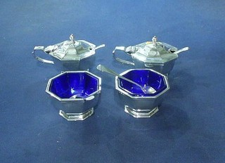 A silver octagonal condiment set comprising 2 mustard pots and 2 mustard spoons, 2 salts with blue glass liners and 2 salt spoons, London 1938 by the Goldsmiths and Silversmiths Co. 19 ozs