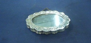 An oval mirror contained in an embossed Eastern silver frame 5"
