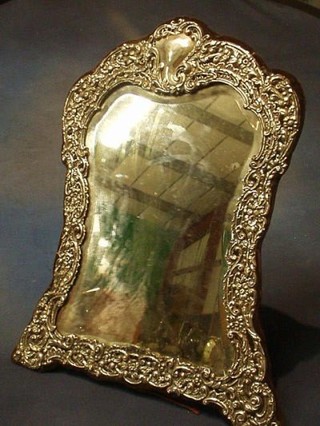 An Edwardian shaped plate easel mirror contained in an embossed silver frame Birmingham 1908 (some holes) 18"