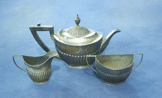 An Edwardian 3 piece silver Bachelor's tea service of oval form with demi-reeded decoration comprising teapot, twin handled sugar bowl and cream jug, London 1900 and 1901, 14 ozs