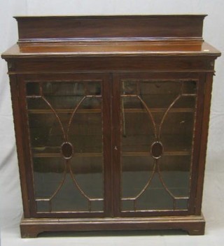 An Edwardian Chippendale style mahogany bookcase with raised back fitted adjustable shelves and enclosed by astragal glazed panelled doors and raised on bracket feet 42"