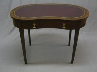 A 19th/20th Century mahogany kidney shaped writing table with inset tooled leather writing surface, fitted a drawer and raised on square tapering supports 42"