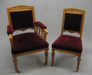 A Victorian honey oak 6 piece drawing room suite comprising 2 open arm chairs and 4 standard chairs with carved cresting rails, the seats upholstered in red Dralon, raised on turned and fluted supports