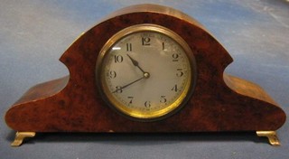 A 1930's French bedroom timepiece  with silvered dial and Arabic numerals contained in an arch shaped figured walnutwood case, raised on brass bracket feet